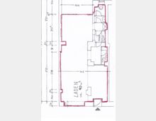 Grundriss eines Ladenlokals mit einer Fläche von ca. 90 m². Der Plan zeigt einen Hauptraum, kleinere Nebenräume, darunter ein Technikraum, sowie genaue Maßangaben und eine markierte Eingangstür.
