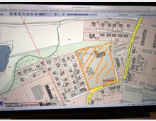 Digitale Flurkarte einer Ortschaft, dargestellt im Brandenburg-Viewer. Gebäude, Grundstücksgrenzen, Straßen und Flurnummern sind eingezeichnet. Ein Bereich in der Karte ist orange markiert und mit "Scheune" beschriftet.