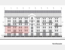 Architektonische Zeichnung der Nordfassade eines mehrstöckigen Gebäudes mit symmetrischer Gestaltung. Die Fassade zeigt zahlreiche Fenster, Balkone und angedeutete Eingänge; ein hervorgehobener Bereich im unteren linken Teil ist rot markiert.