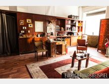 Ein gemütlich eingerichtetes Zimmer im Vintage-Stil mit Holzvertäfelung, einem Schreibtisch, Bücherregalen, Sesseln und dekorativen Elementen wie einem Hirschkopf an der Wand. Im Raum sind ein großer Teppich, diverse Bücher und nostalgische Accessoires zu sehen, beleuchtet durch ein Fenster mit Tageslicht.