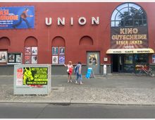 Außenansicht eines Kinos mit roter Fassade und dem Schriftzug "UNION". Plakate aktueller Filme und Veranstaltungen sind an der Wand angebracht; links ein Werbeplakat für ein Mittelalterfestival, rechts der Eingang mit einem gelben Vordach und den Worten "KINO CAFÉ BISTRO".