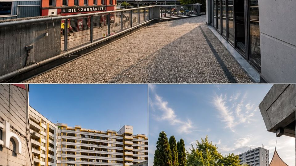 Erhöhte Dachterrasse bzw. umlaufender Gehweg mit Kieselboden und Metallgeländern zwischen mehrstöckigen Gebäuden, mit Blick auf eine rote Backsteinfassade und umliegende Stadtbebauung. Ein Bereich der Terrasse ist mit Lounge-Möbeln, Pflanzkübeln und einem Sonnensegel ausgestattet.