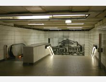 U-Bahn-Station mit gefliesten Wänden, einer Rolltreppe auf der linken Seite und einem großen Wandbild im Hintergrund, das eine historische Gebäudeansicht zeigt. Oben ist ein Schild mit der Linienbezeichnung „S2 Oranienburg / Bernau (b Berlin)“ zu sehen.