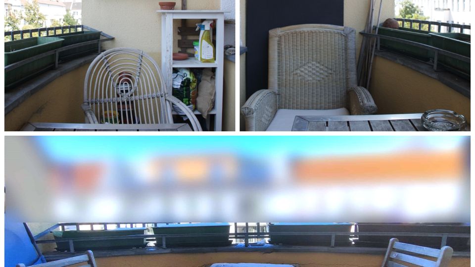 Small apartment balcony with a yellow stucco wall and black railing, lined with rectangular planter boxes. The space includes a wicker chair, a small table with two wooden chairs, and a white storage shelf beneath a sloped roof overhang.