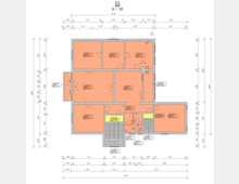 Grundrisszeichnung eines Erdgeschosses im Maßstab 1:100. Zu sehen sind mehrere Räume in rechteckiger Anordnung, mit eingezeichneten Türen, Fenstern und Wänden sowie Maßangaben entlang der Ränder. Ein zentral platzierter Treppenbereich und ein Aufzugsschacht sind farblich hervorgehoben.