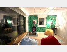 Wohnraum mit Holzofen und gemütlicher Sitzecke. Die Wände sind mit grünem Tapetenmuster dekoriert, es gibt ein Fenster, mehrere Sitzsäcke und einen kleinen Beistelltisch.