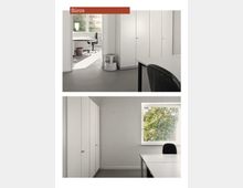 Zwei helle Büroräume mit minimalistischer Einrichtung. Beide Räume verfügen über weiße Schränke und Tische, grauen Bodenbelag und große Fenster, die viel Tageslicht hereinlassen; Außenansicht mit grünen Bäumen sichtbar.