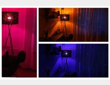 Collage aus drei Bildern eines modern eingerichteten Zimmers mit einer Standleuchte, die jeweils in pinkem, orangefarbenem und blauem Licht leuchtet. Im Hintergrund sind transparente Vorhänge, ein Schreibtisch, Pflanzen und Wandregale zu sehen.