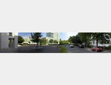 Städtische Straßenszene mit mehrspuriger Fahrbahn, geparkten und fahrenden Autos, sowie modernen Bürogebäuden und Grünflächen im Hintergrund. Auf der linken Seite ist ein weißes Gebäude mit Säuleneingang sichtbar, umgeben von Bäumen und Gehwegen.