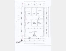 Grundriss eines Einfamilienhauses mit Beschriftungen der Räume, darunter Schlafzimmer, Büro, Küche, Wohnzimmer, Flur und Badezimmer. Pfeile markieren Eingang, Terrasse, Norden und Garten, und genaue Maße sind entlang der Außenwände sowie zwischen den Räumen angegeben.