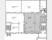Grundrisszeichnung eines Gebäudes mit verschiedenen Räumen und Flächen. Beschriftet sind ein Workshop (50 m²), Yard (70 m²), Fundus (50 m²), Studio (100 m², mit Maßen: 9,7 m x 8,7 m und einer Höhe von 3,40 m) sowie eine Holzwerkstatt (20 m²) und WC-Bereiche. Treppen befinden sich auf beiden Seiten des Plans.