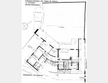 Grundrisszeichnung eines Wohnhausneubaus in Jüterbog von Konrad Wachsmann. Die Zeichnung zeigt das Erdgeschoss mit Lageplan, einschließlich beschrifteter Räume wie Küche, Wohnraum und Eingangsbereich, sowie dem umliegenden Gelände mit Straßenverlauf und historischer Stadtmauer.
