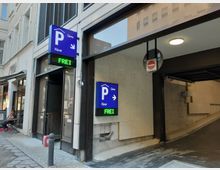 Eingang zu einem Parkhaus in einer Stadt mit blau beleuchteter Beschilderung „P Fürst“ und einem grünen Schild „FREI“. Rechts davon befindet sich eine Einfahrt mit Steinwänden und einem „Einfahrt verboten“-Schild; links sind Teile eines Gebäudes mit einem Geschäft und Sitzbereich sichtbar.