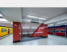 U-Bahn-Station mit gelber U-Bahn auf der linken Seite, rot gefliesten Wänden und einem Treppenabgang in der Mitte. Rechts ist eine Wand mit einer norwegischen Flagge und der Aufschrift „Osloer Straße“ zu sehen, Hinweis auf die Linie U8 oben rechts im Bild.