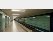 U-Bahn-Station mit einem langen, leeren Bahnsteig, grün gefliesten Wänden und einer gegenüberliegenden Wand aus großen, hellgrünen Glasscheiben mit der Aufschrift „Amrumer Straße“. Die Gleise verlaufen in der Mitte, während helle Deckenbeleuchtung den Bereich ausleuchtet.