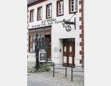 Fassade eines historischen Gebäudes mit der Aufschrift "G.F. Wittke. Koch und Vieh: Salz-Niederlage". Vor dem Eingang befindet sich ein Schild mit der Aufschrift "Museum" und einem Ausstellungsplakat, daneben hängt ein ornamentiertes Schild mit der Inschrift "Kreismuseum".