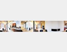 Panoramablick auf ein modernes Loft mit sichtbaren Backsteinwänden, Holzbalkendecken und offener Raumaufteilung. Im Vordergrund sind ein Essbereich, eine Küchenzeile mit Holzelementen und ein Wohnbereich mit Kamin und großen Fenstern zu sehen.