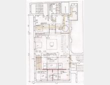 Grundrisszeichnung eines Gebäudes mit detaillierten Angaben zu Räumen, Treppen, Podium, Sanitäranlagen und baulichen Elementen wie abgehängten Decken und Glasbausteinwänden. Verschiedene Bereiche sind mit Beschriftungen, Maßen und Pfeilen zur Belüftung und Konstruktion versehen.