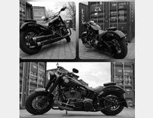 Schwarz-weiß-Bilder einer schweren Cruiser-Motorradmaschine, fotografiert aus verschiedenen Winkeln vor gestapelten Schiffscontainern auf einem gepflasterten Industriegelände. Die Details des Motorrads, wie die verchromten Teile, der breite Hinterreifen und die geschwungene Form des Lenkers, sind gut sichtbar.