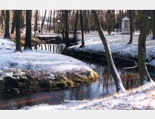 Ein schneebedeckter Park mit kahlen Bäumen, durch den ein kleiner Bach fließt. Im Hintergrund sind eine Holzbrücke und ein gläserner Pavillon sichtbar.