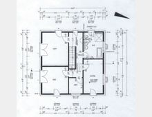 Grundriss eines Wohnhauses mit Beschriftungen der Räume wie "Gast," "Kind," "Bad," "Eltern," "Abstellraum" und "Diele." Der Plan enthält Maßangaben, Türen, Fenster und Raumaufteilungen sowie Umrisse von Einrichtungsgegenständen, z. B. Badewanne und Treppe.