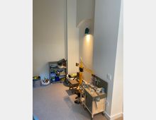 Ein Kinderzimmer mit hellem Teppichboden, einer Spielecke mit einem Spielzeugkran und einer Holzwerkbank. An der Wand befinden sich ein kleines Regal mit Spielzeug und eine Leuchte, die eine gewölbte Nische beleuchtet.